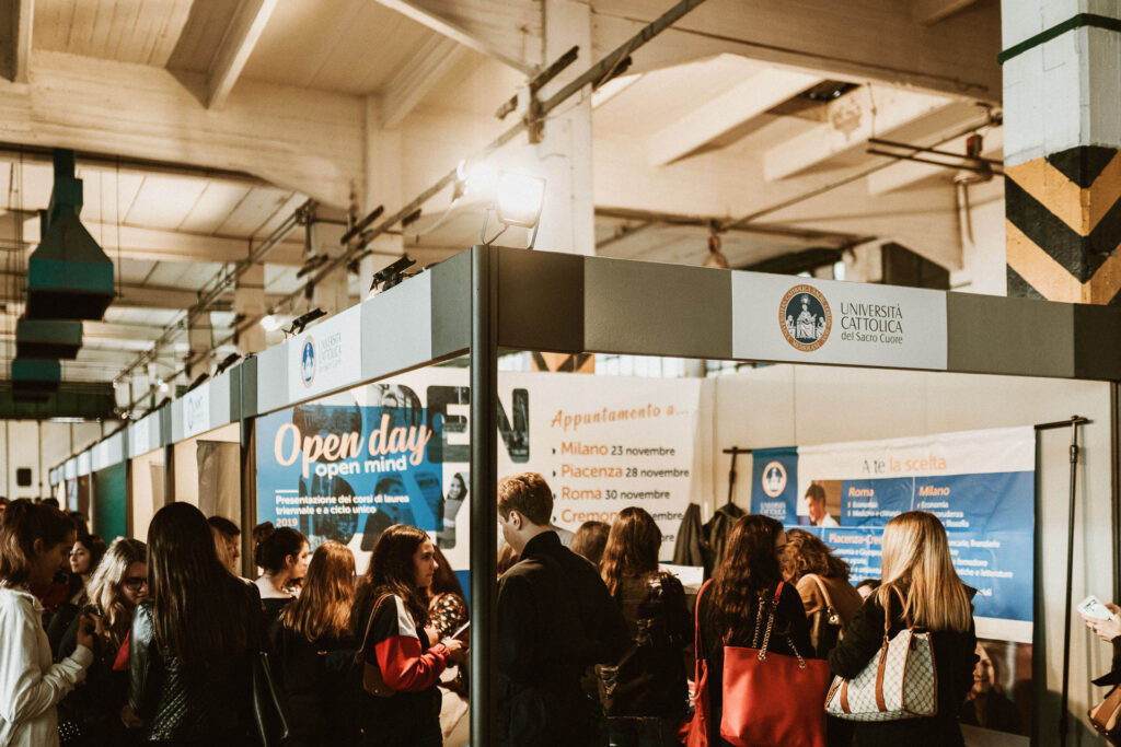 Area espositiva con stand e visitatori durante un evento